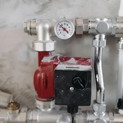 Industrial process control system with red pump, valves, and pressure gauge