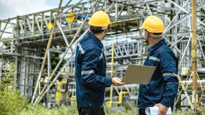 Chemical engineers discussing plant operations in an industrial facility
